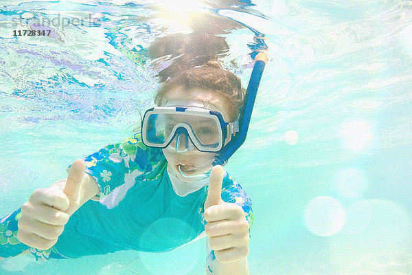 Porträt selbstbewusstes Mädchen beim Schnorcheln unter Wasser  Geste Daumen hoch