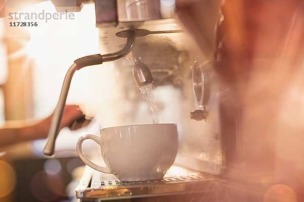 Nahaufnahme einer Espressomaschine  die eine Kaffeetasse mit heißem Wasser füllt