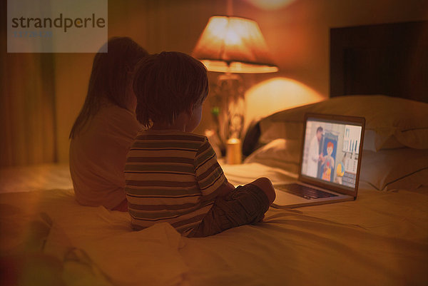 Junge und Mädchen Bruder und Schwester beobachten Video auf Laptop auf dem Bett