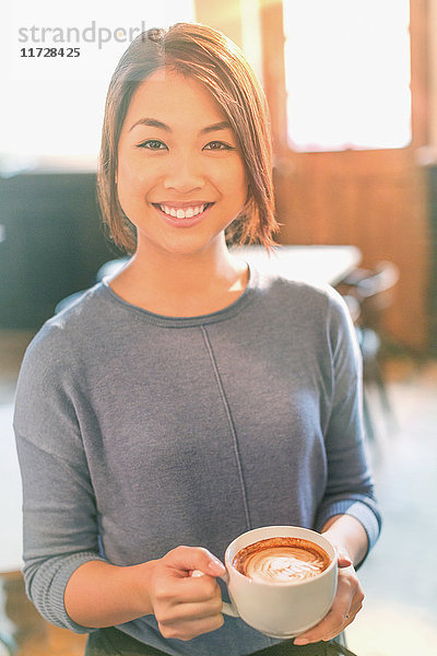Porträt lächelnde chinesische Frau trinkt Cappuccino im Café