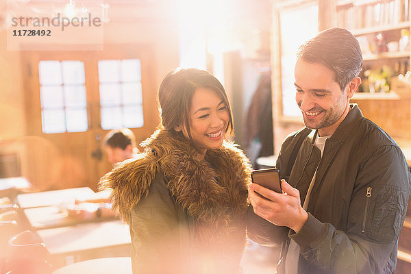 Paar benutzt Mobiltelefon in einem Café