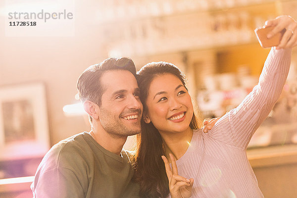 Lächelndes Paar gestikuliert Friedenszeichen nehmen Selfie mit Kamera-Handy