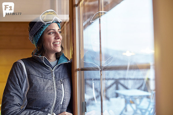 Lächelnde Skifahrerin mit Blick aus dem Kabinenfenster