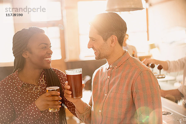 Lächelndes Paar trinkt Bier in einer Bar
