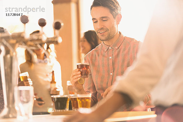 Mann probiert Bier in der Bar einer Kleinbrauerei