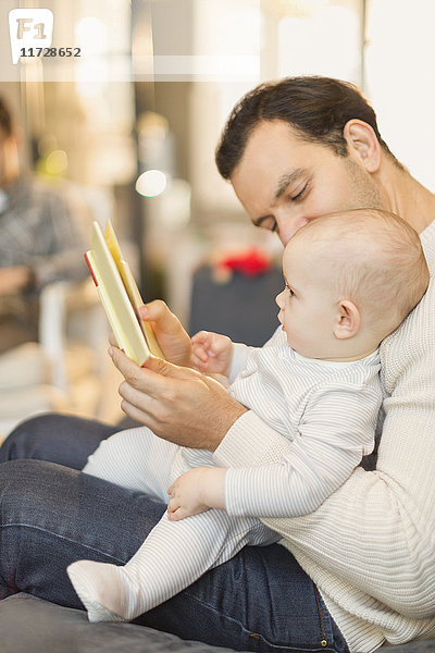Vater liest Buch zum süßen Baby-Sohn