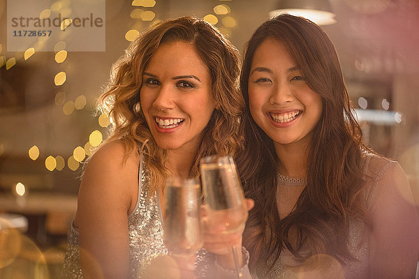 Porträt lächelnd Frauen Freunde Toasting Champagner-Flöten