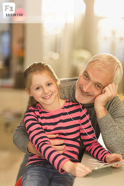 Portrait lächelnd Vater und Tochter verbinden  Kopfhörer teilen und digitales Tablett benutzen