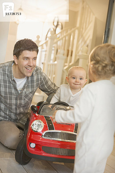 Vater und Söhne spielen mit Spielzeugauto