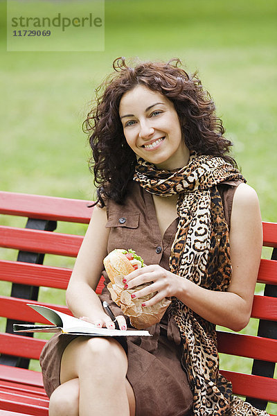 Geschäftsfrau sitzt auf einer Bank in einem Park in der Pause von der Arbeit