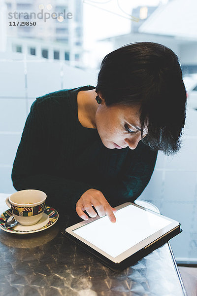 Frau im Café mit Touchscreen auf digitalem Tablet