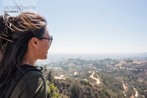 Junge Frau schaut vom Hollywood-Zeichen auf die Landschaft  Los Angeles  Kalifornien  USA