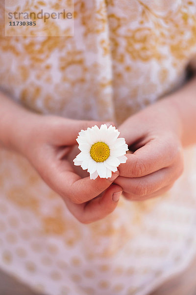 Schrägansicht eines Mädchens mit Gänseblümchen