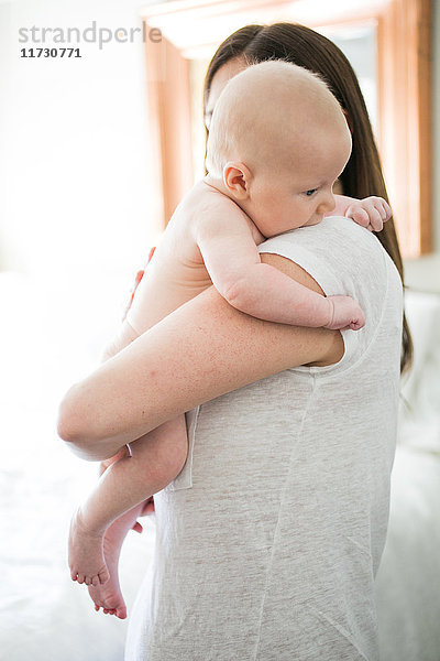 Mutter umarmt Baby Junge  Rückansicht