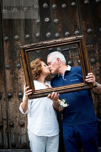 Porträt eines älteren Paares  küssend  einen Holzrahmen vor dem Gesicht haltend  Mexiko-Stadt  Mexiko