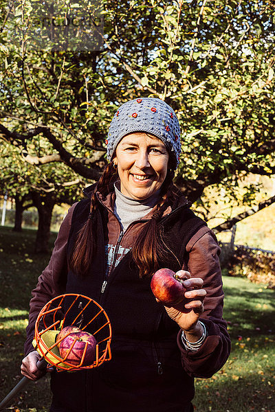 Porträt einer Frau mit Obstpflückerin und frischem Apfel