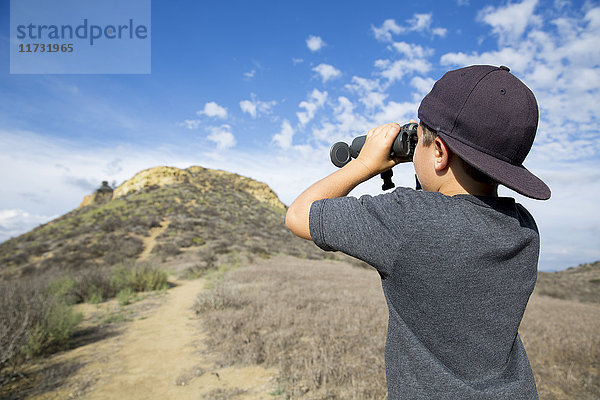 Junge  der durch ein Fernglas die Landschaft betrachtet  Thousand Oaks  Kalifornien USA