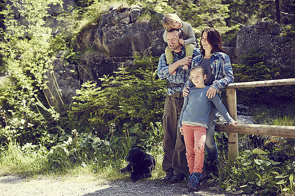Bildnis einer Familie  im Wald  am Zaun stehend