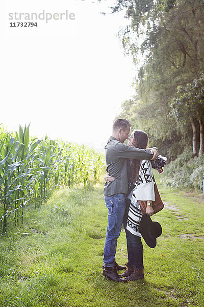 Romantisches Paar  das sich auf dem Feld umarmt