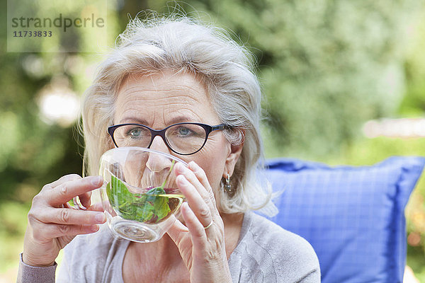 Ältere Frau  Entspannung im Garten  Getränk