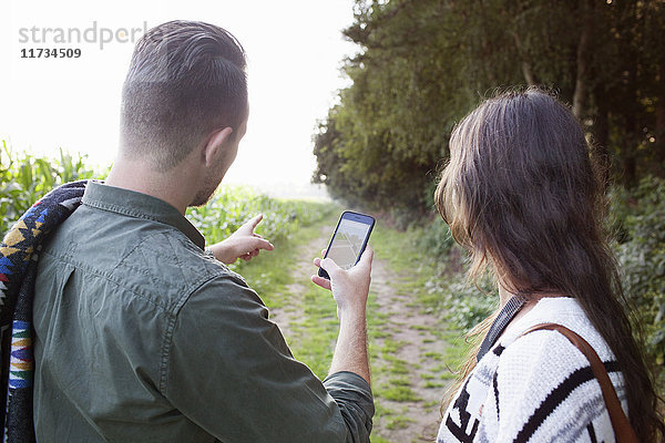 Über-Schulter-Ansicht eines Paares  das vor Ort mit einem Smartphone navigiert