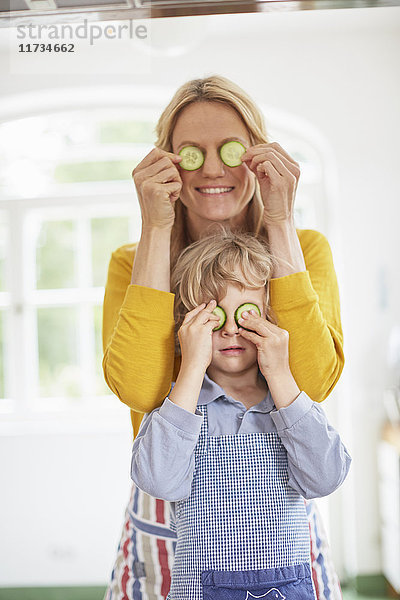 Mutter und Sohn bedecken die Augen mit Gurkenscheiben