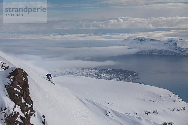Mann beim Snowboarding am Berg Eskifjordur  Island