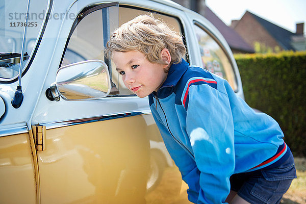 Junge schaut in den Außenspiegel eines Autos