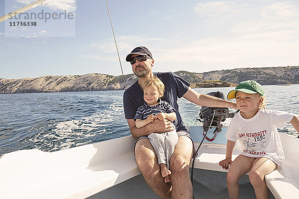 Älterer Mann steuert Motorboot mit Söhnen  Lopar  Insel Rab  Kroatien
