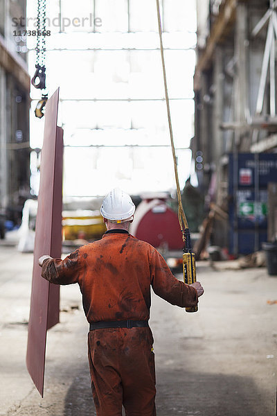 Rückansicht eines Arbeiters mit Winde in der Werftwerkstatt