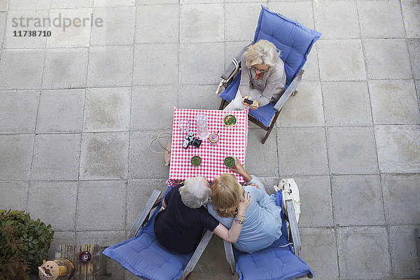 Drei Frauen sitzen im Garten  trinken etwas und genießen die Aussicht von oben