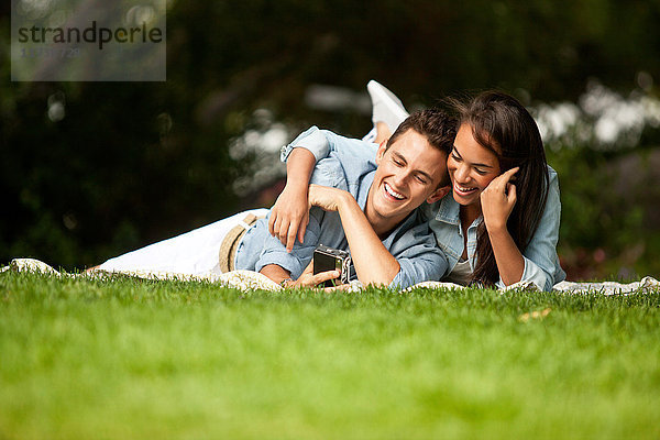 Junges Paar im Park liegend  lächelnd