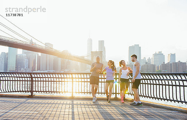 Junge erwachsene Läufer im Gespräch vor der Brooklyn Bridge  New York  USA