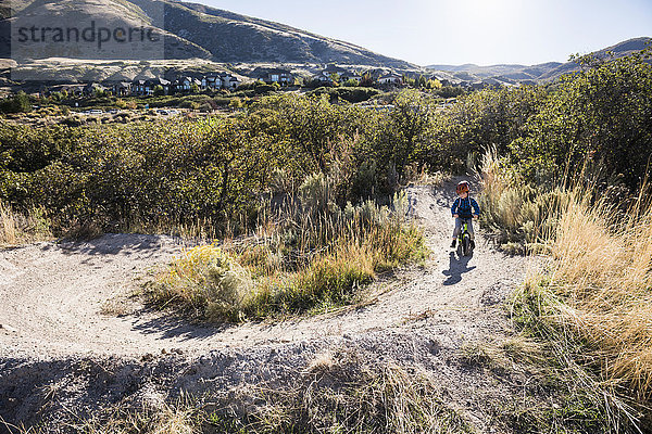 Junge fährt Gleichgewichtsrad auf Feldweg  Draper-Radpark  Missoula  Montana  USA