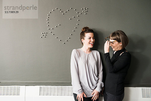 Zwei Frauen an der Wand mit Herzform