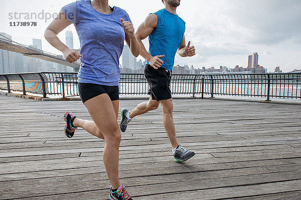 Männliche und weibliche Läufer beim Laufen am Flussufer  New York  USA