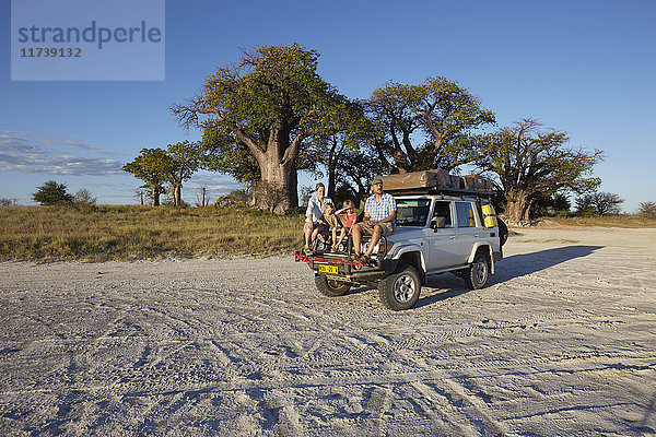 Ehepaar mit Söhnen auf Fahrzeug  Nxai-Pan-Nationalpark  Kalahari-Wüste  Afrika