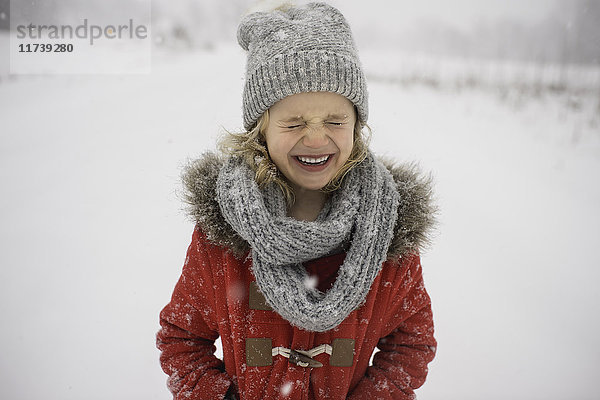 Glückliches junges Mädchen läuft im Schnee