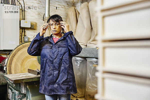Porträt einer Frau  die in der traditionellen Druckwerkstatt eine Schutzbrille aufsetzt
