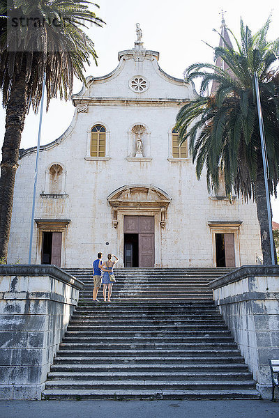 Rückansicht eines jungen Paares  das zur Kirche aufschaut  Milna  Brac  Kroatien