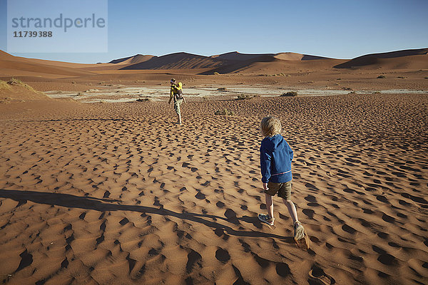 Junge wandert in der Wüste  Namib Naukluft National Park  Namib Wüste  Sossusvlei  Dead Vlei  Afrika