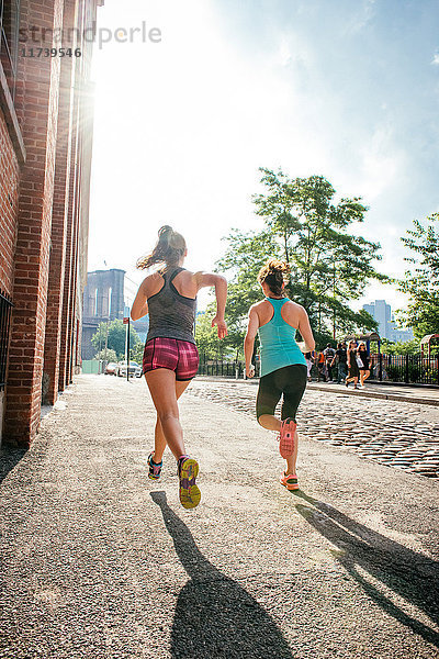 Zwei junge Läuferinnen laufen am Flussufer  Brooklyn  New York  USA