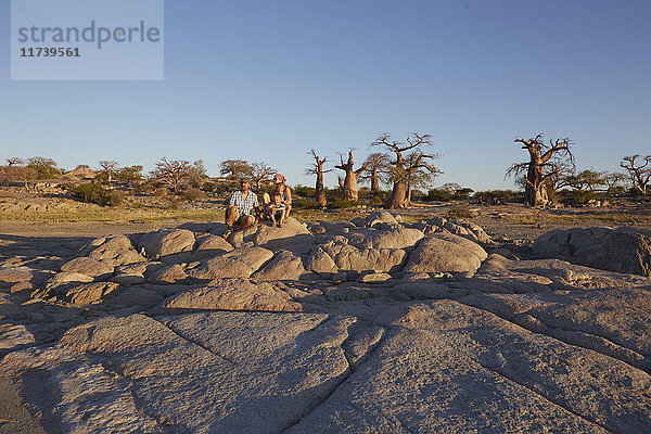 Familie sitzt auf Felsen und schaut auf die Aussicht  Gweta  makgadikgadi  Botswana