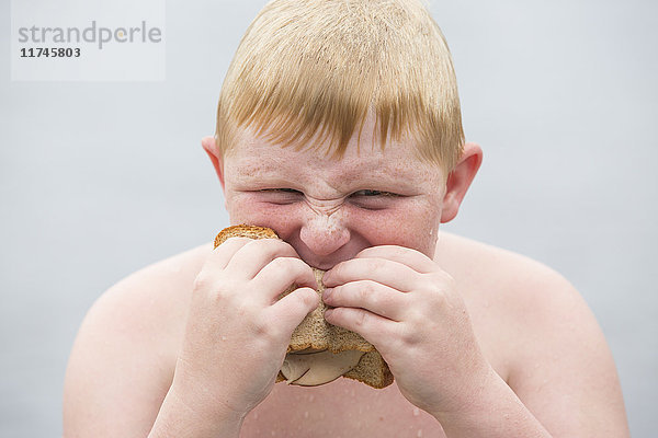 Porträt eines Jungen  der ein Sandwich isst