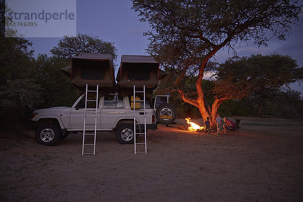Geländewagen geparkt  Familie sitzt am Lagerfeuer  Purros  Kaokoland  Namibia