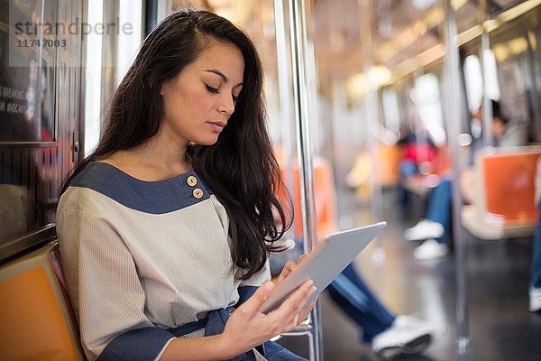 Mittelgroße erwachsene Frauen mit digitalem Tablet in der U-Bahn  New York