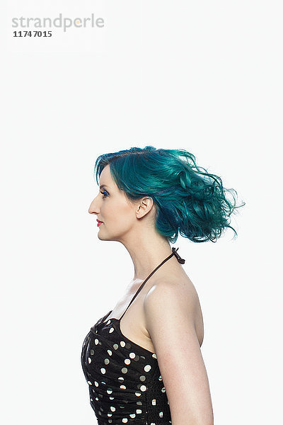 Junge Frau mit grünen Haaren im Profil vor weißem Hintergrund