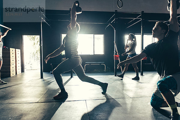 Menschen  die mit Kettlebell im Fitnessstudio trainieren