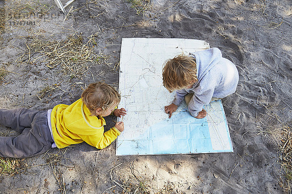 Jungen lesen Karte auf Schotterstraße