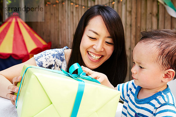 Mutter macht einem kleinen Jungen ein Geburtstagsgeschenk